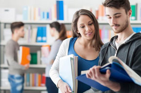 Mujer con sueter blanco y playera azul junto a un hombre con sudadera gris y con libros en manos