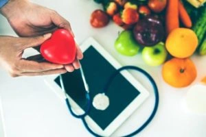 Frutas, tablet y estetoscopio sobre una mesa sobre la Licenciatura en Nutrición.