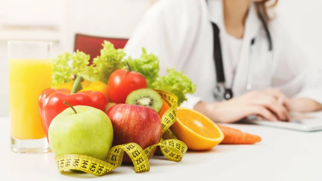 Nutriologa con frutas y verduras en su escritorio.