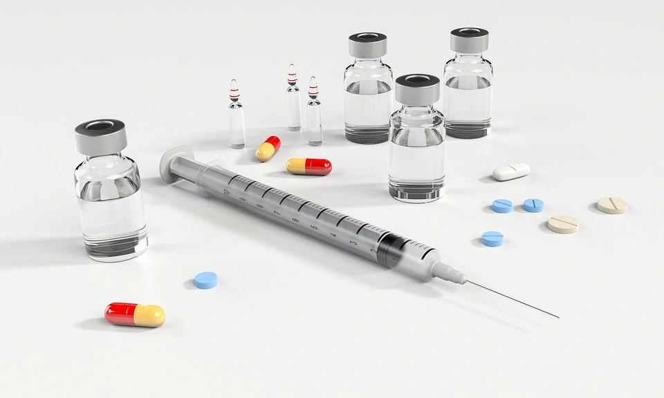 Pastillas, jeringa y líquidos de medicina.