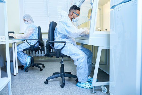 2 personas realizando prácticas en laboratorio sobre epidemiología.