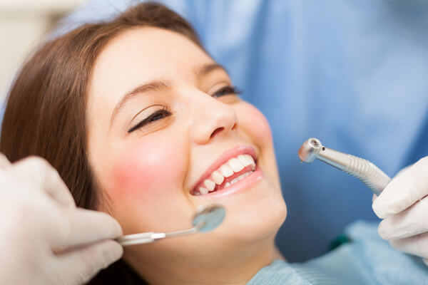 Sonriente paciente de odontología en servicio de higiene bucal.